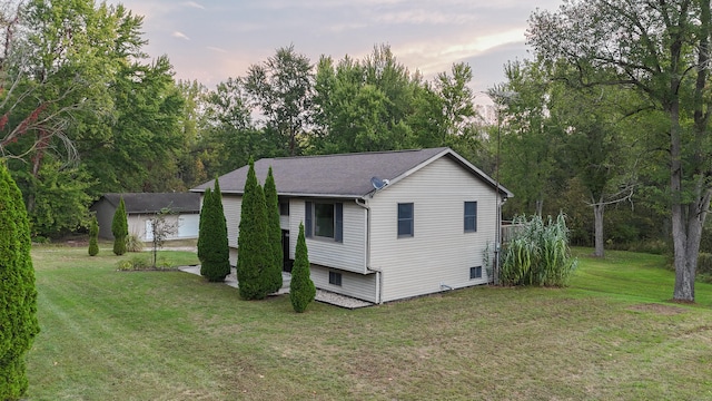 property exterior at dusk featuring a lawn