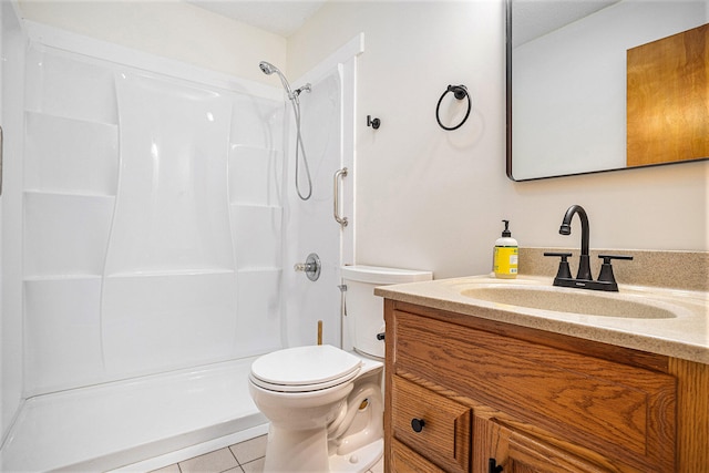 bathroom featuring toilet, tile patterned flooring, a shower, and vanity