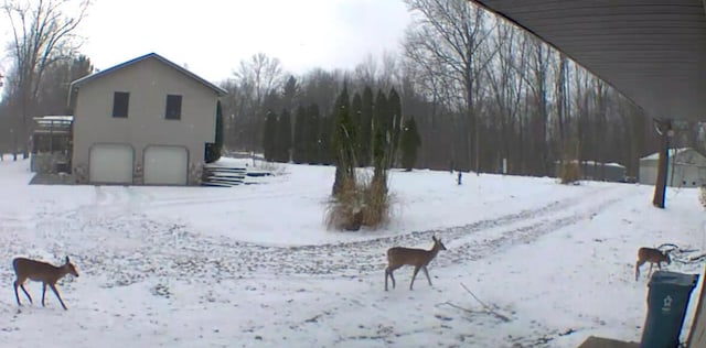 snowy yard featuring a garage