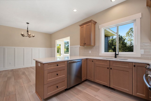 kitchen with kitchen peninsula, sink, stainless steel dishwasher, and a healthy amount of sunlight