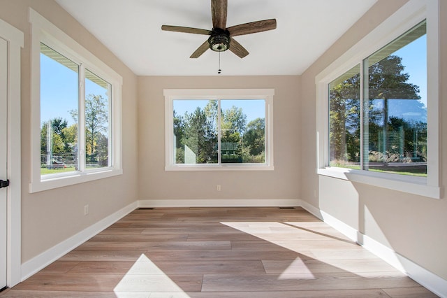 unfurnished sunroom featuring ceiling fan