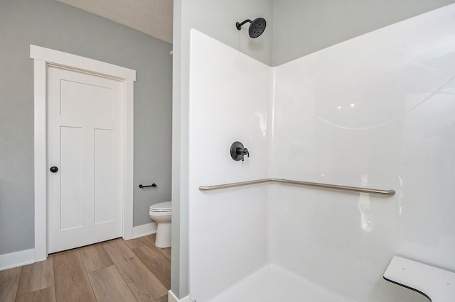 bathroom with wood-type flooring, a shower, and toilet