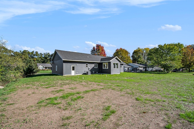 rear view of property featuring a lawn