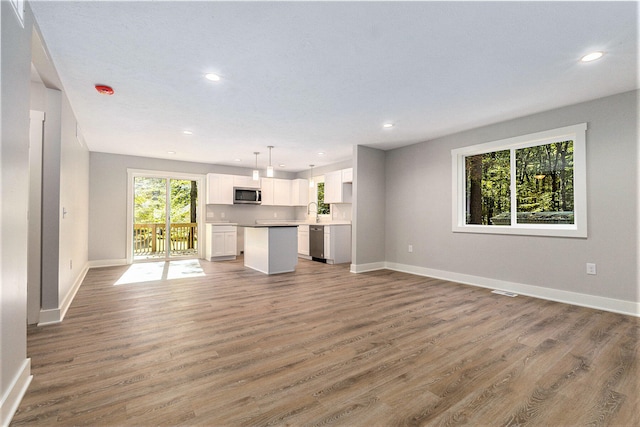 unfurnished living room featuring dark wood-type flooring and sink