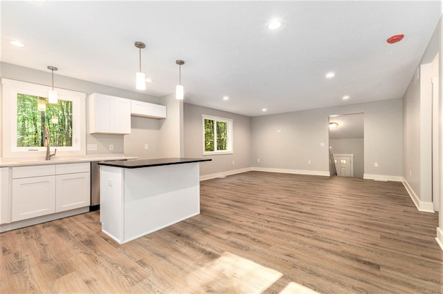 kitchen with pendant lighting, light hardwood / wood-style floors, and white cabinetry