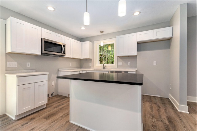 kitchen featuring white cabinetry, decorative light fixtures, dark hardwood / wood-style floors, and a kitchen island