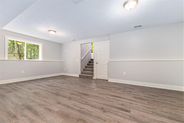 unfurnished room featuring a textured ceiling and dark wood-type flooring