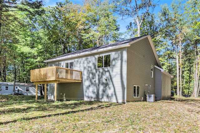 back of property featuring central AC unit and a lawn