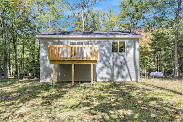 rear view of house with a deck and a yard