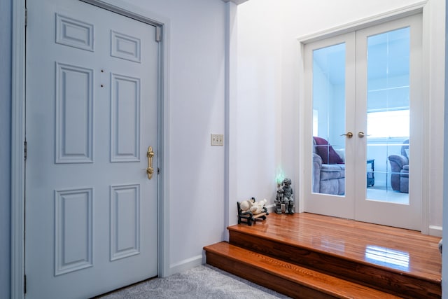 carpeted foyer featuring french doors