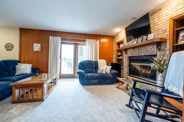 carpeted living room with wooden walls, a textured ceiling, and a fireplace