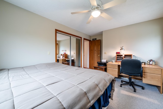 carpeted bedroom featuring a textured ceiling, ceiling fan, and a closet