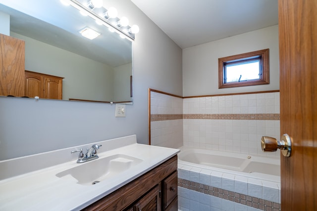 bathroom featuring tiled bath and vanity