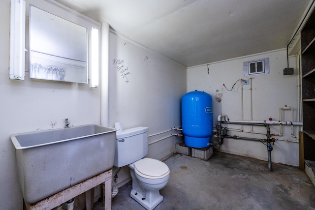 bathroom featuring concrete flooring, sink, and toilet