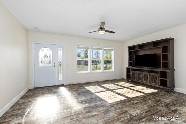 unfurnished living room featuring ceiling fan and dark wood-type flooring