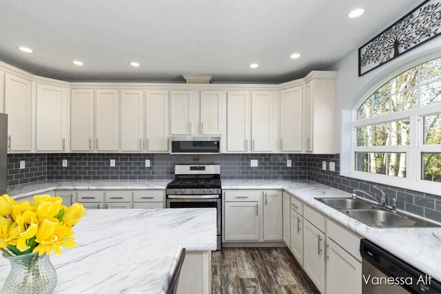 kitchen with white cabinets, appliances with stainless steel finishes, decorative backsplash, and sink