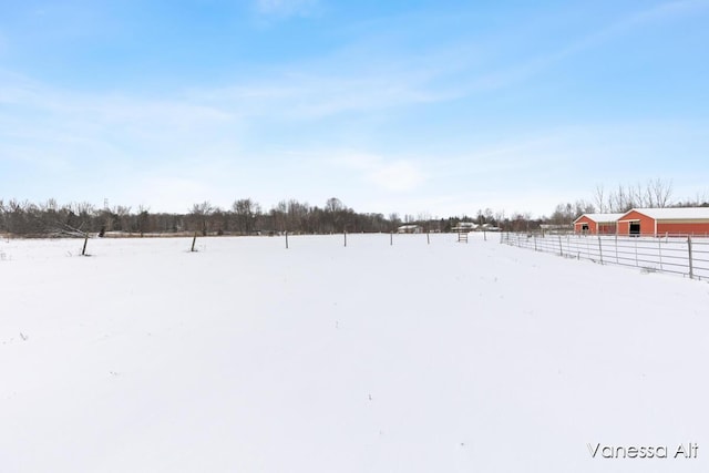 yard covered in snow featuring a rural view