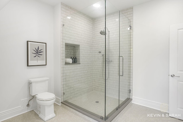 bathroom featuring tile patterned flooring, toilet, and walk in shower