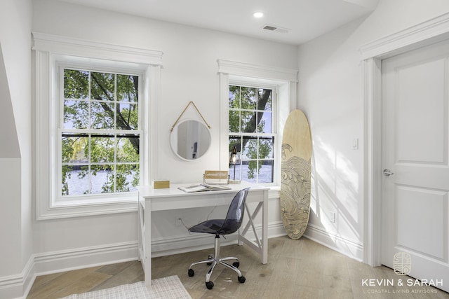 home office with light hardwood / wood-style flooring