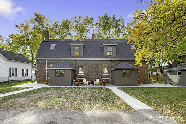 view of front facade featuring cooling unit and a storage shed