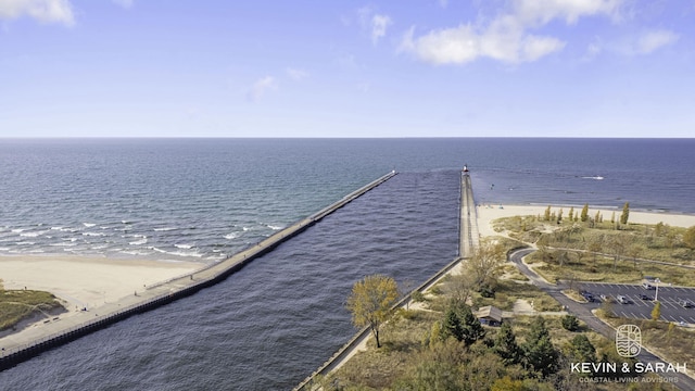 birds eye view of property with a water view and a beach view