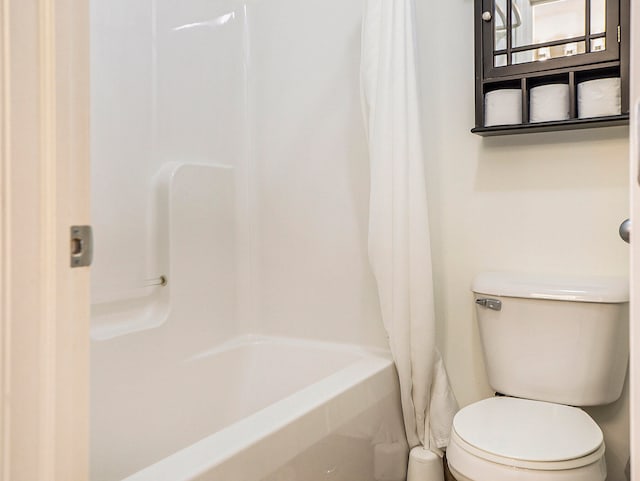 bathroom with shower / bath combination with curtain and toilet