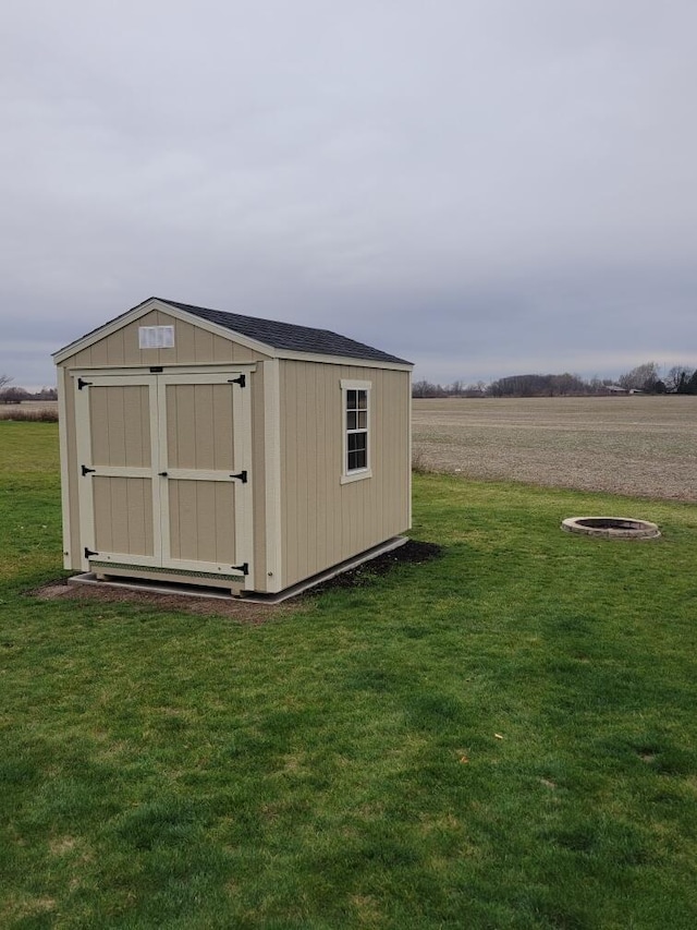 view of outdoor structure featuring a rural view and a yard