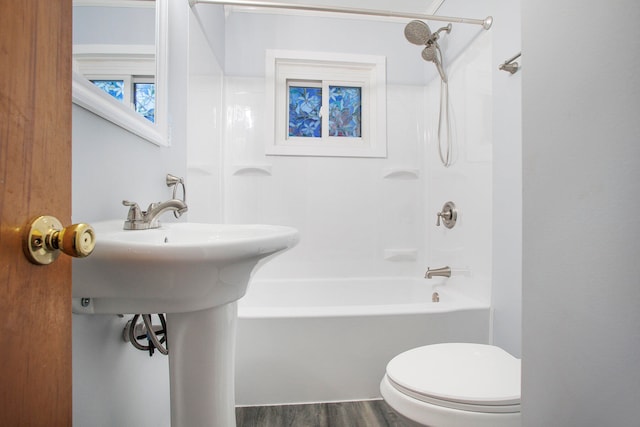 bathroom featuring toilet, hardwood / wood-style flooring, and shower / tub combination