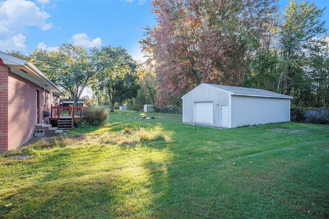 view of yard featuring a garage, a wooden deck, and an outdoor structure