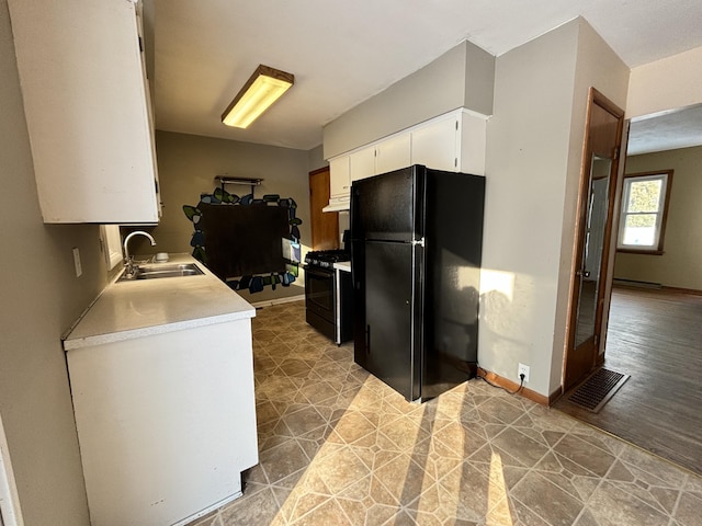 kitchen featuring sink, white cabinets, and black appliances