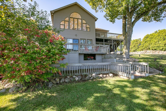 rear view of house featuring a wooden deck and a yard