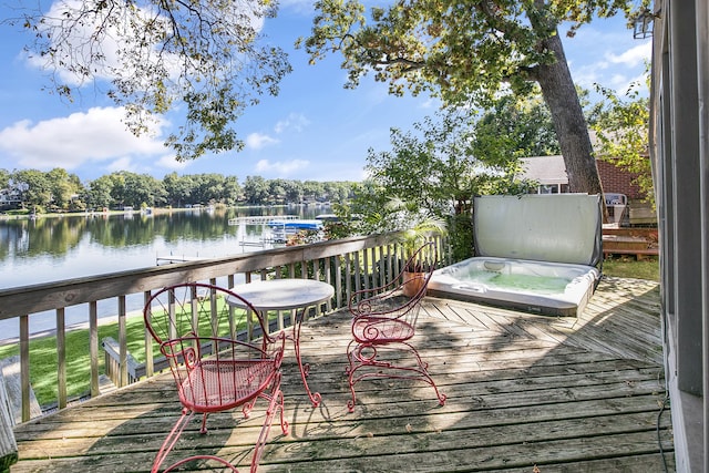 wooden terrace featuring a water view and a covered hot tub