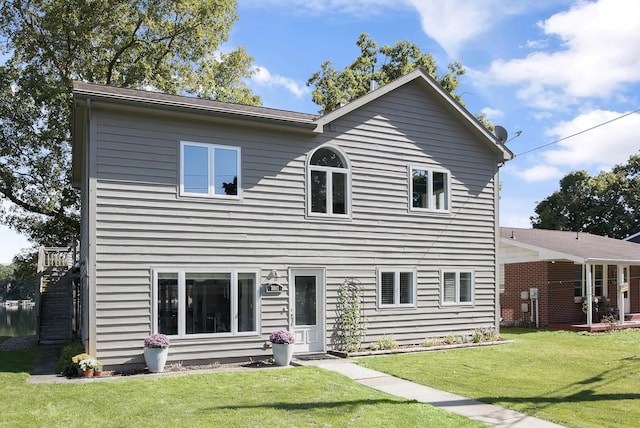 rear view of house featuring a yard