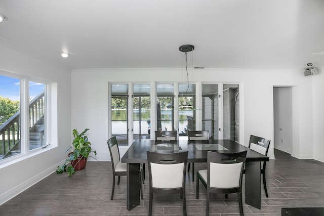 dining area with crown molding and dark wood-type flooring