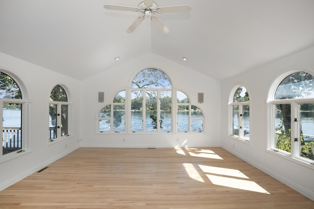 interior space featuring a water view, vaulted ceiling, and light hardwood / wood-style flooring