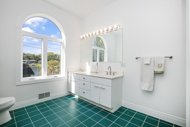 bathroom with vanity, tile patterned flooring, toilet, and a wealth of natural light