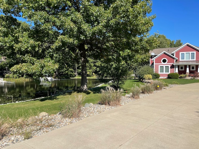 view of front of property featuring a water view and a front lawn