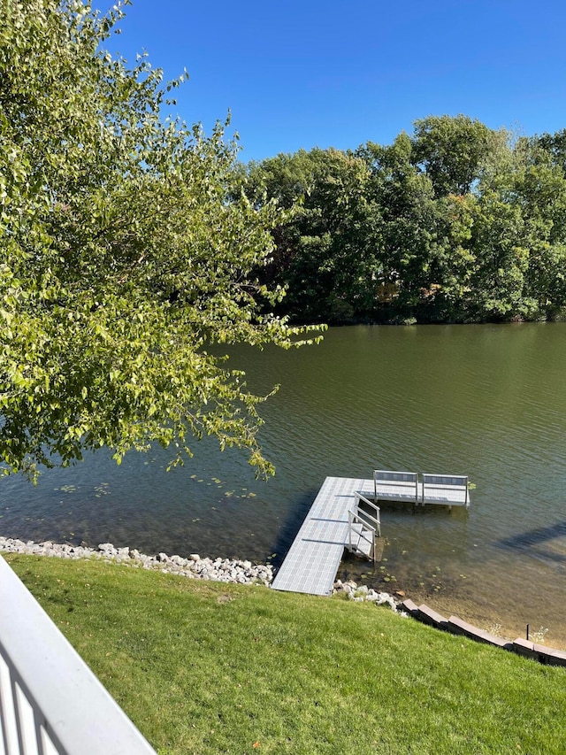 dock area with a lawn and a water view