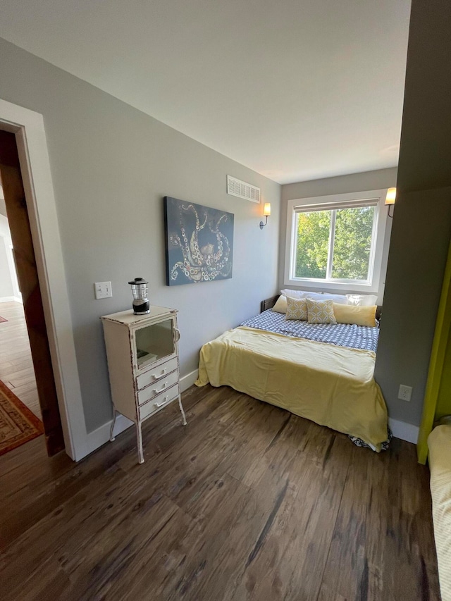 bedroom with dark hardwood / wood-style floors