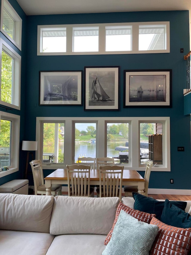 living room featuring a healthy amount of sunlight, a water view, and hardwood / wood-style floors