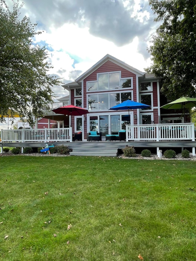 back of house featuring a lawn and a wooden deck