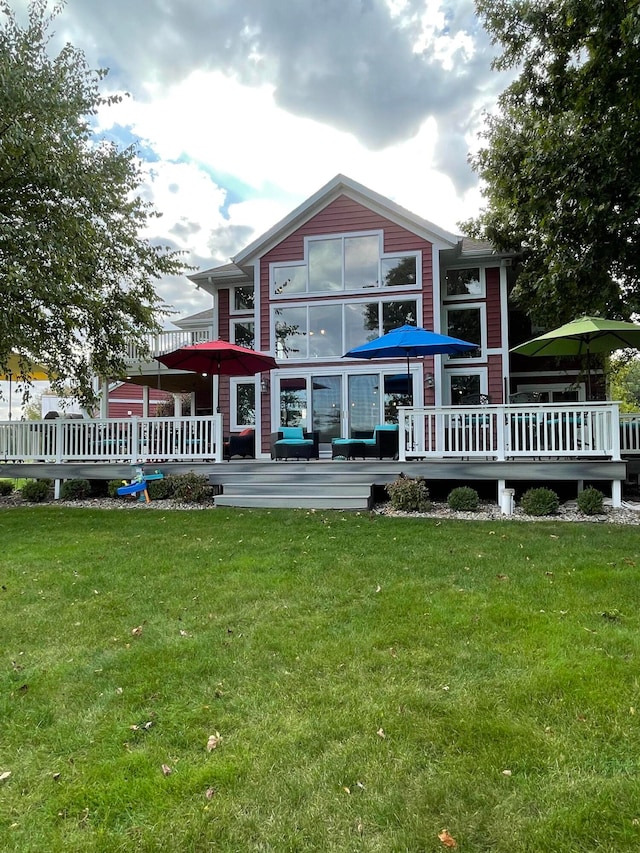 rear view of property featuring a lawn and a wooden deck