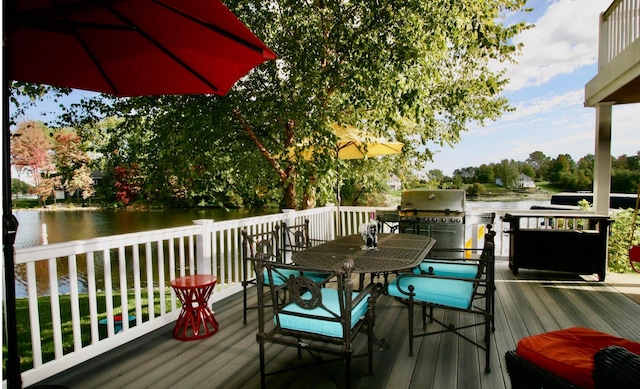 wooden terrace with a grill and a water view