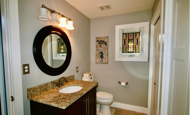 bathroom with tile patterned flooring, vanity, and toilet