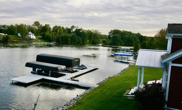 view of dock featuring a lawn and a water view