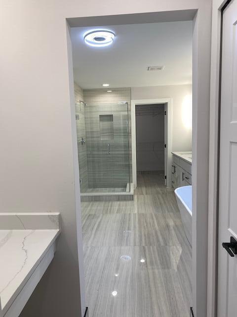 bathroom with vanity and independent shower and bath