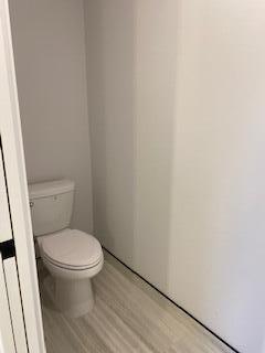 bathroom with toilet and hardwood / wood-style flooring