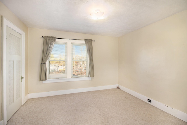 carpeted empty room featuring a textured ceiling