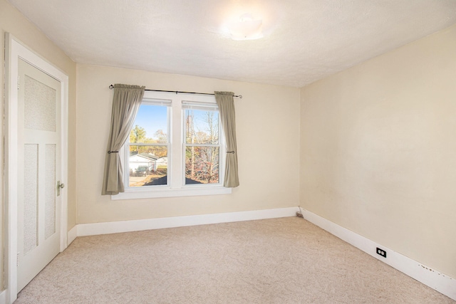 unfurnished room with light carpet and a textured ceiling