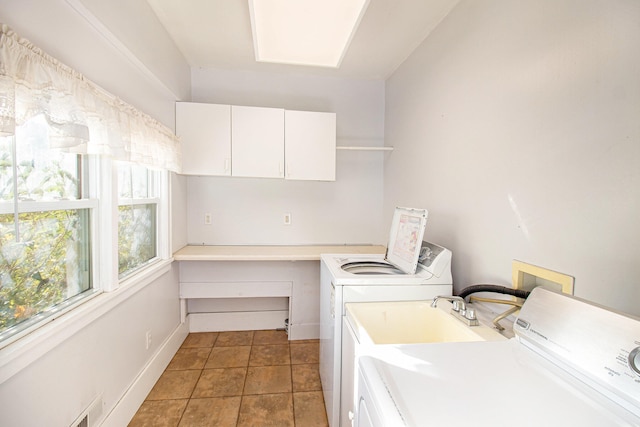 clothes washing area featuring independent washer and dryer, tile patterned flooring, and cabinets